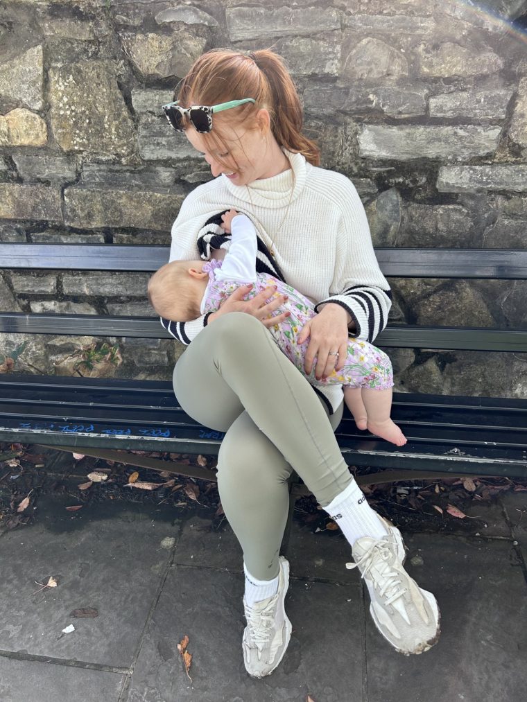 Image of a mum sitting on a bench breastfeeding her baby.